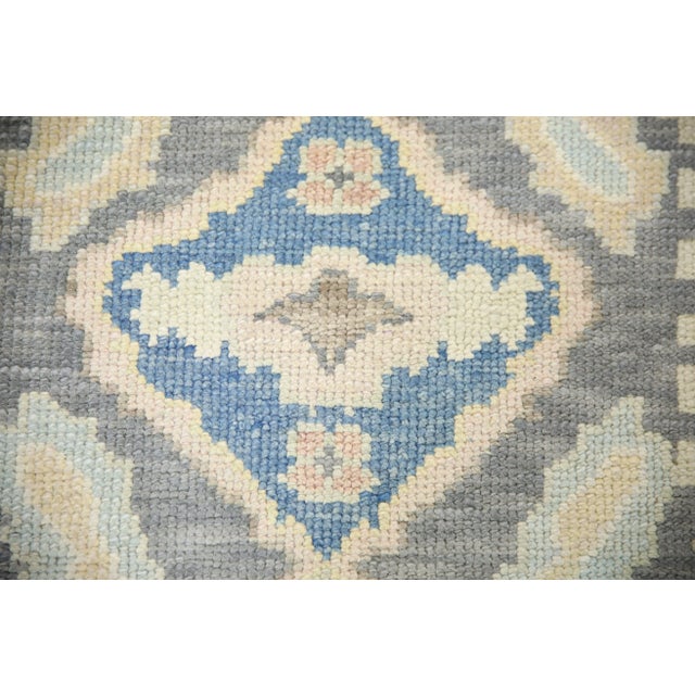 This modern Turkish Oushak rug is a stunning piece of art that has been handwoven using traditional techniques by skilled...