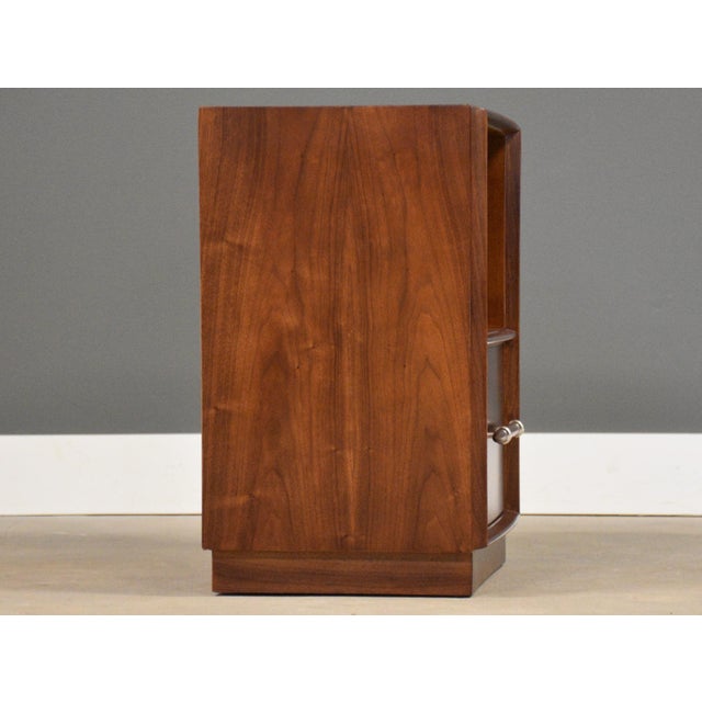 A mid century modern walnut spear tip nightstand designed by T.H. Robsjohn Gibbings for Widdicomb with aluminum ring...