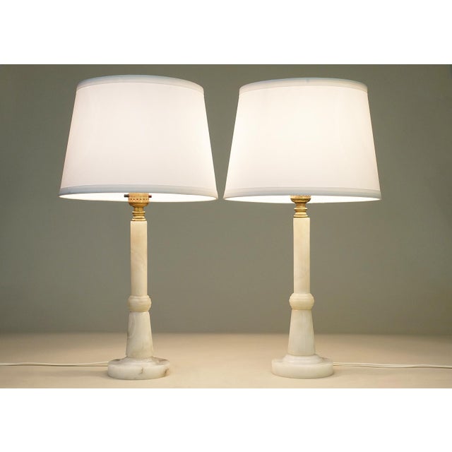 A brilliant and striking pair of slender Streamline Art Deco styled solid Milky white Alabaster Marble candlestick table...