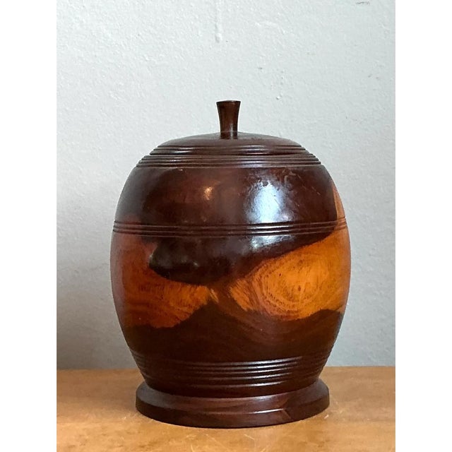 This vintage turned wood lidded vessel is a study in warm, sculptural craftsmanship. Its plump, globular body swells...