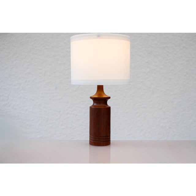 A beautifully crafted vintage danish teak table lamp from the 1960s, showcasing the refined simplicity and classic...