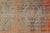 This is a vintage Turkish Oushak rug from the Mid 20th Century. The piece was hand-knotted.