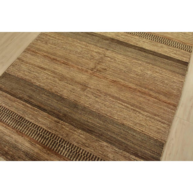 A contemporary Gabbeh rug hand-knotted with fine wool on a cotton foundation. This rug features small geometric patterns...