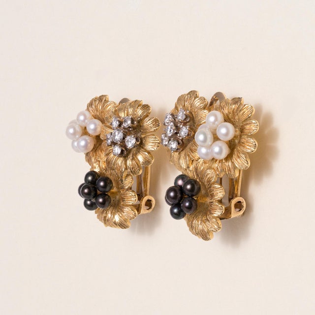 14K Yellow Gold | Circa 1960s A graceful example of mid-century elegance, these vintage floral clip-on earrings combine...