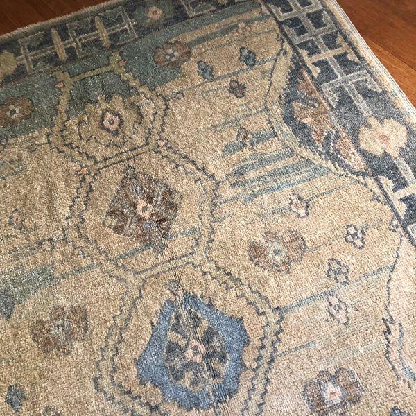 A refined contemporary Oushak, this hand-knotted Turkish rug features a soft beige field layered with light and deep blue...