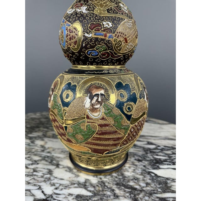 Pair of Satsuma ceramic vases, richly decorated with figures in traditional costumes, as well as numerous symbolic motifs...