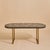 A French brass and ceramic mosaic coffee table from the 1960s, defined by its elongated oval form and richly textured...