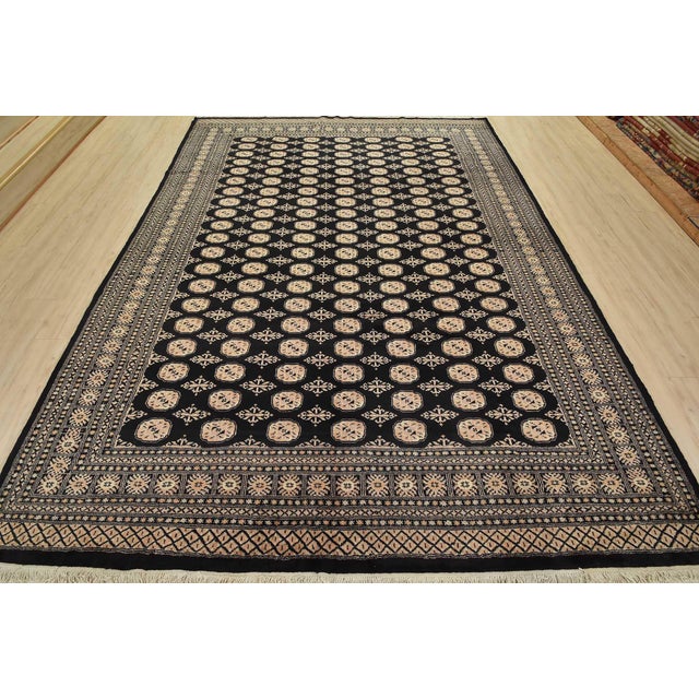 A tribal Bokhara rug hand-knotted with fine wool on a cotton foundation. This rug features rows of repeating medallions...