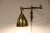 This wall lamp features a swivel arm, and is in iron and brass in a style reminiscent of Bauhaus. European Plug (up to...