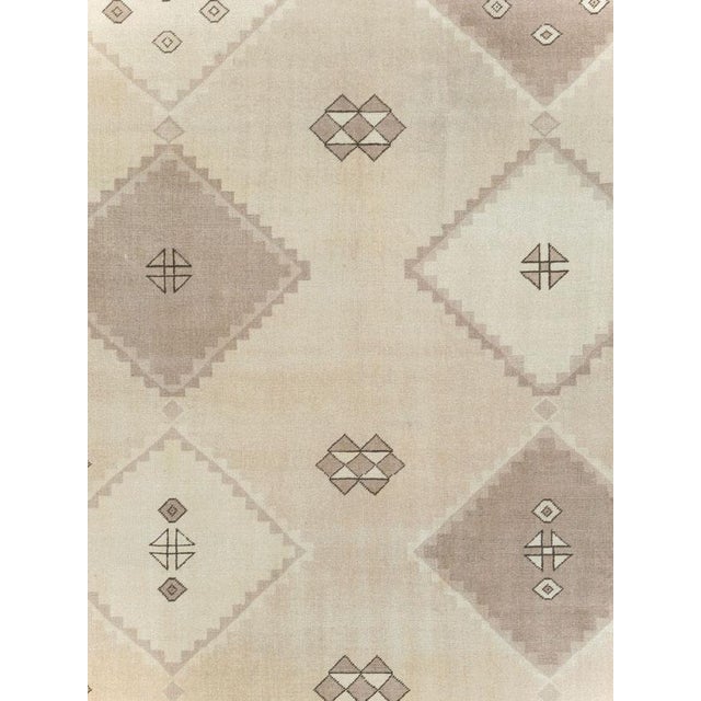 This Mid-20th century Turkish Anatolian room-size carpet presents a calm geometric composition in a restrained palette of...