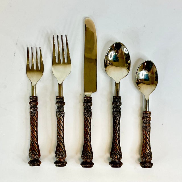 This is a stunning set of very high quality stainless steel flatware. The handles are finished in a bronze tone. We do not...
