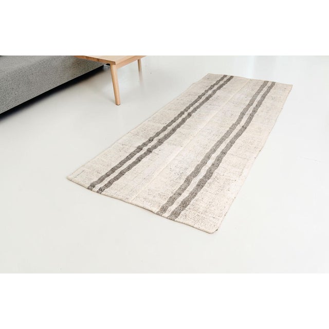 This is a vintage Turkish Oushak rug from the Mid 20th Century. The piece was hand-knotted.