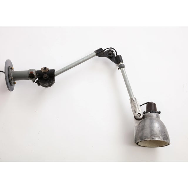 Industrial Anglepoise wall-mounted cast iron sconce, c. 1940. The Anglepoise lamp is a balanced-arm lamp designed in 1932...