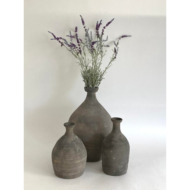 This rustic hand thrown pottery bottle in shades of gray adds an organic element to any space. The narrow neck...