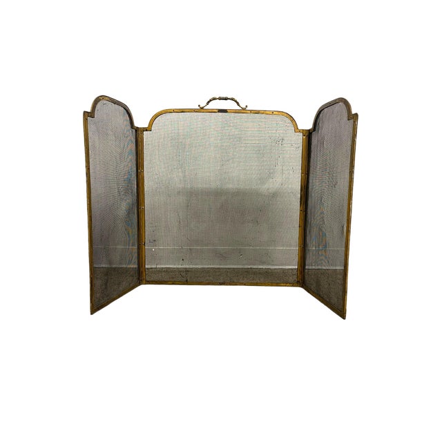 Vintage three-panel fireplace screen featuring a brass-toned metal frame with fine mesh infill. The design includes a...