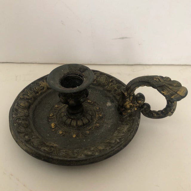 Heavy pot metal candle stick with thumb/finger hold and mark on bottom reads Modell Schultz