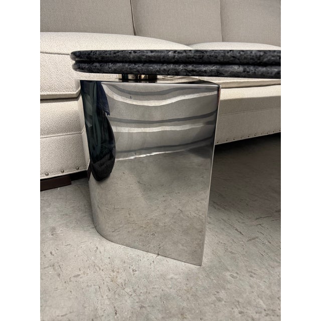 Striking Mid-Century Modern coffee table featuring a substantial triangular specimen granite top supported by three...