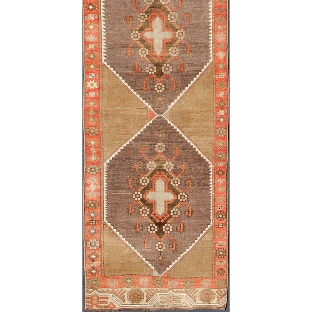 Long and narrow vintage runner from Turkey with multi geometric diamond medallion design in camel background, rust, gray,...