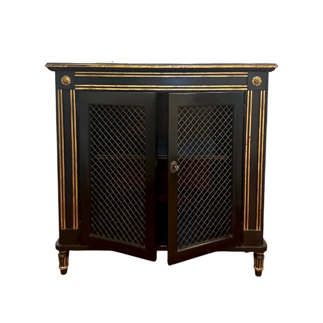 A stunning, mid-century Regency/Directoire style cabinet. Features black finish accented with gilt detailing and inset...