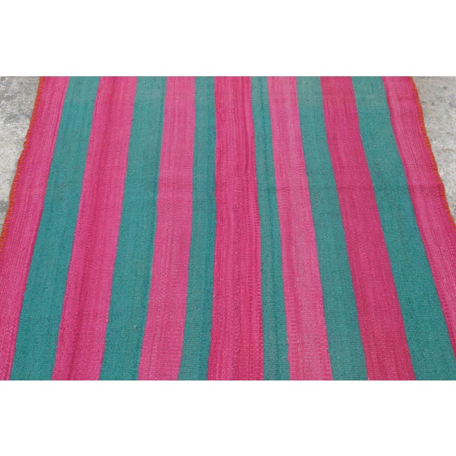Hand-woven in wool circa 1950-1960, this 4x6 vintage Peruvian Kilim—traditionally known as a Frazada—is a vibrant and...