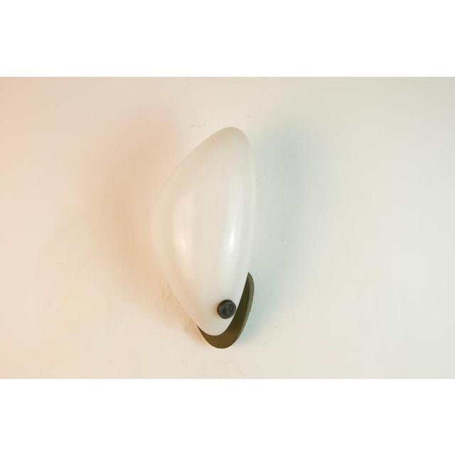 Sculptural german wall lamp from the 1960s, featuring an organically shaped white acrylic-glass diffuser mounted on a...