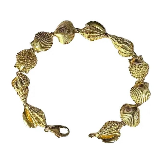 Vintage 14K Yellow Gold Charm Bracelet. Bracelet is meticulously crafted with a series of beautifully detailed seashells....