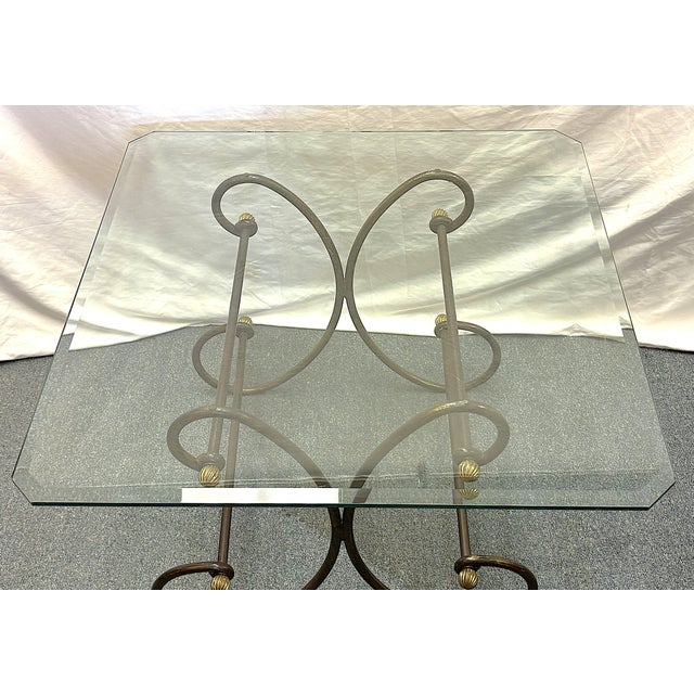 Vintage scroll wrought iron and brass accent table from the late 20th century. The base is made of wrought iron and...