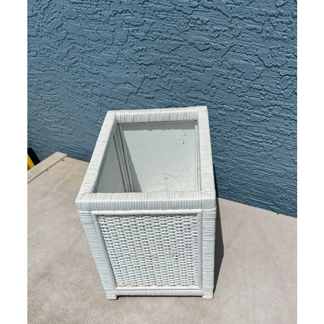This is a white wicker trash can or wastebasket, likely vintage, featuring a rectangular shape and woven texture. This...