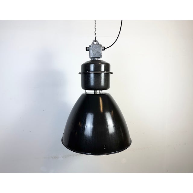 This large black industrial factory pendant light was designed and produced by elektrosvit in former czechoslovakia during...