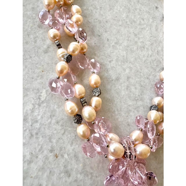 A uniquely designed freshwater pearl necklace inclusive of gorgeous pink crystal detailing and silver metal flower...