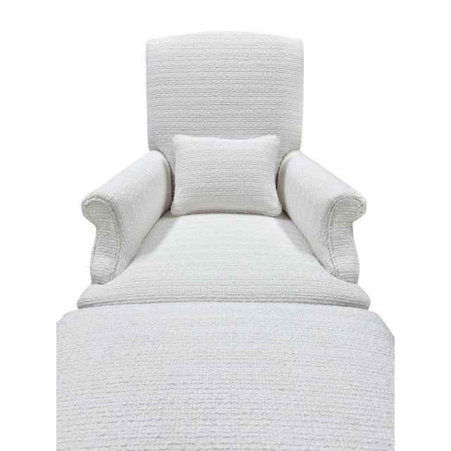 Elegant chaise lounge upholstered in soft cream bouclé, featuring gently rolled arms, a high supportive back, and a...