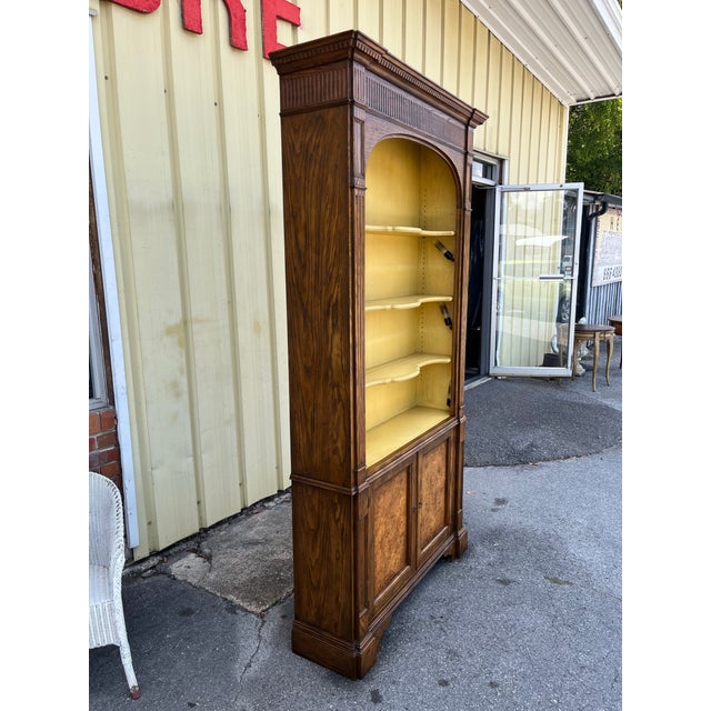 Vintage shelving display cabinet by Baker Furniture Company. The piece features a classic design with a richly toned oak...