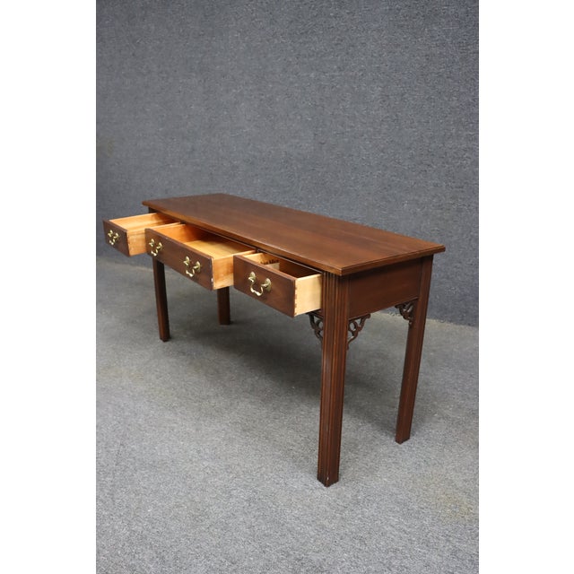 Ethan Allen cherry console table featuring four dovetailed drawers with original brass bail pulls. The table has a...