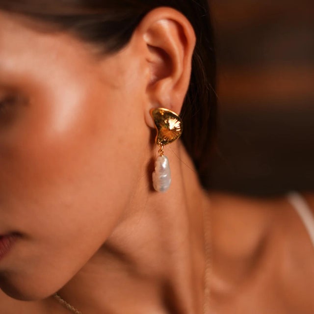 Sea Shell Design Pearl Dangle Earrings, featuring 24k gold plated see shell stud earrings. The delicate baroque pearl drop...