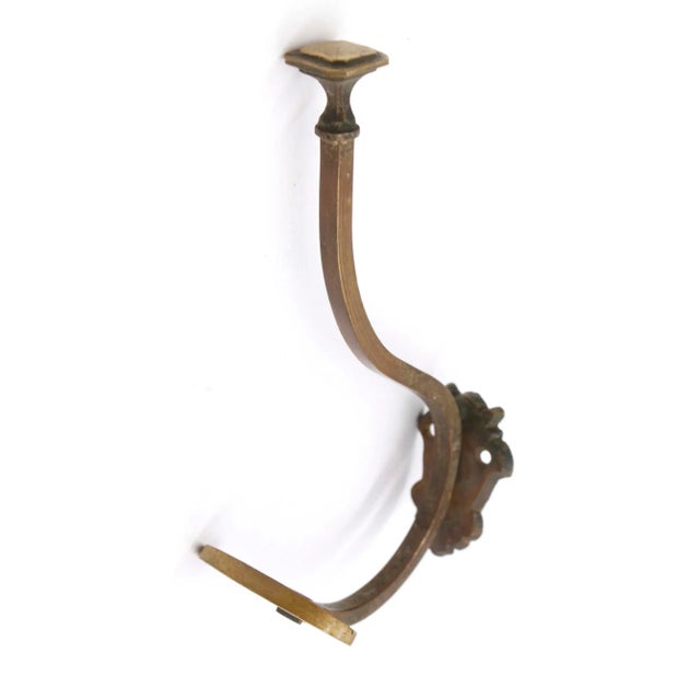 Imported bronze wall hook with an antique patina. One available. The manufacturer and exact date of creation are unknown....