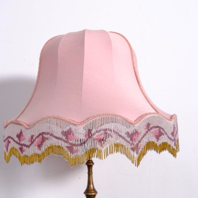 This pair of vintage table lamps features a brass base and pink lampshades decorated with beaded fringe. 1960s/1970s...