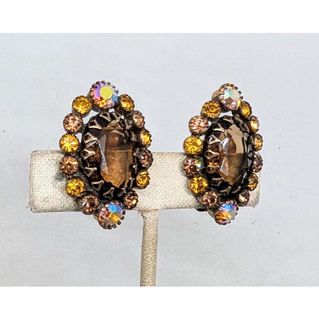 1960s goldtone prong set oval unfoiled open backed faux-topaz with round orange aurora borealis at the top and bottom with...