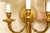 A pair of high quality and heavy gilt bronze Louis XVI Neoclassical Revival style three-arm wall sconces with rosette-...