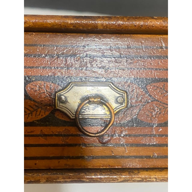 This small wooden box dates from the early 19th century, most likely from Europe. The lower section opens with a front...