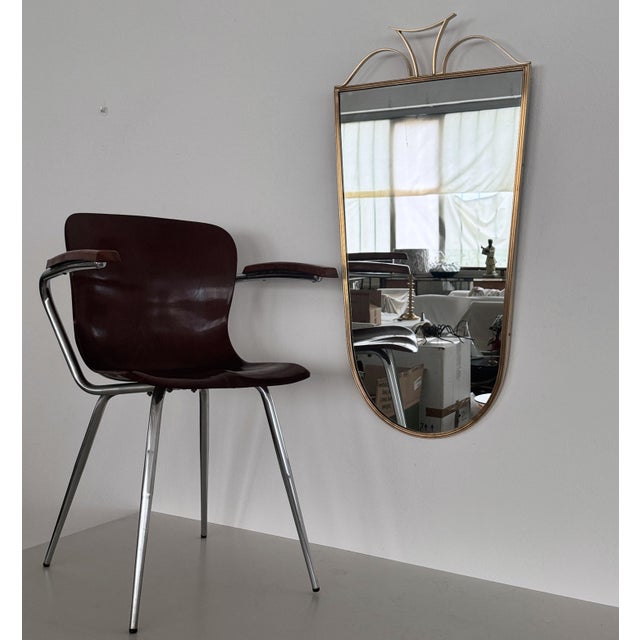Beautiful and elegant large wall mirror with brass frame and decorations. Made in Italy in the 1970s. The brass frame have...