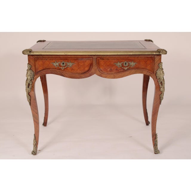 Antique Louis XV style king wood and tulip wood leather top desk with bronze mounts, circa 1920's. The top with an inset...