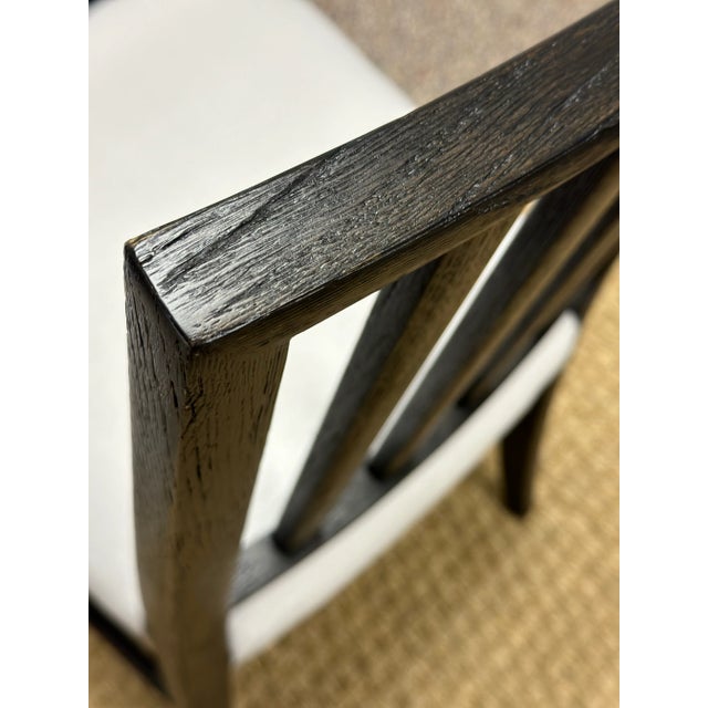 Beautiful dining chairs by Jonathan Charles have a black finish that shows off the wood grain. The simple Gustavian style...