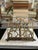 An ornate vintage folding book stand with an openwork brass-tone metal frame and adjustable easel-style support. The...