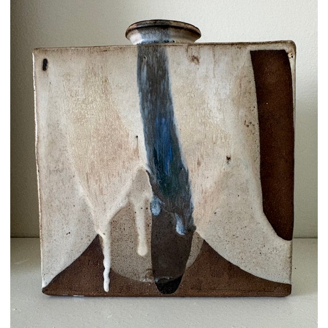 A vintage style ceramic square shaped pottery vessel with a Mid-Century era design. An abstract in neutral and blue tones...