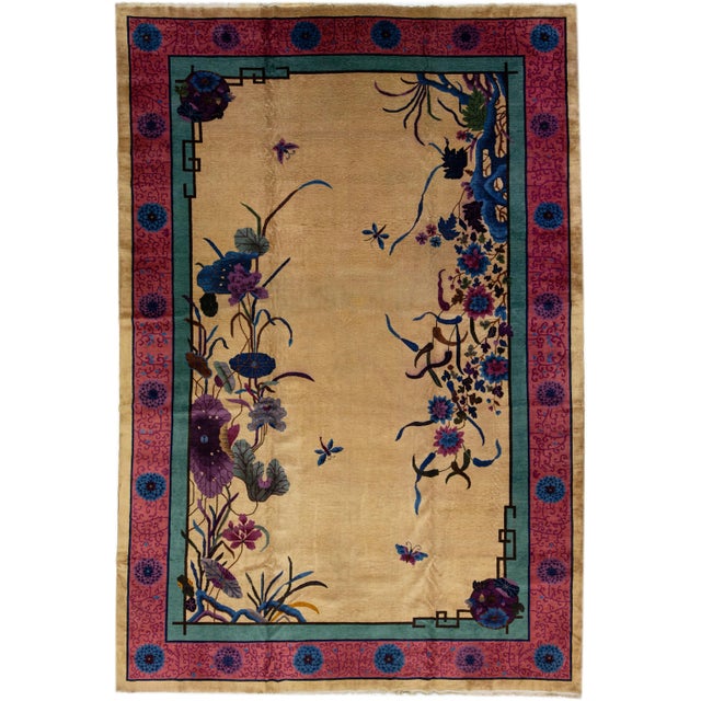 A beautiful Oversize Chinese Nichols hand-knotted wool rug with a tan field red and green frame, and multicolor accents in...