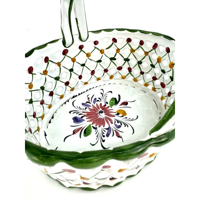 Hand-painted ceramic basket by R.E.C. of Portugal, showcasing a finely detailed lattice design adorned with colorful...