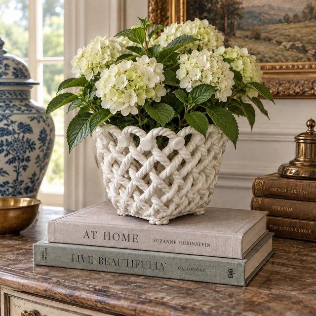 An elegant trompe l'oeil porcelain cachepot crafted in the form of a handwoven rope basket. Executed in glossy white...