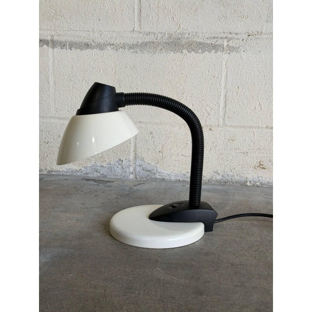 This adjustable gooseneck desk lamp features a flexible neck for directed lighting. Vintage 1980s. Crafted with a white...