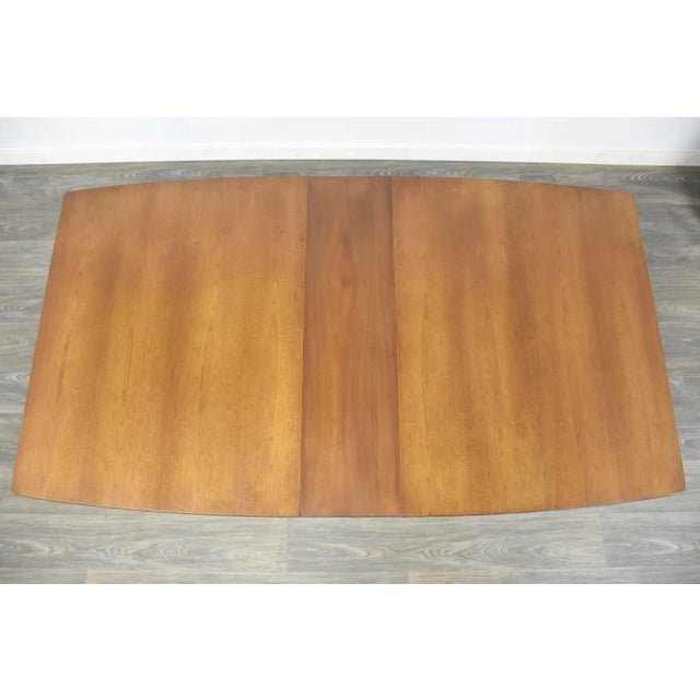 Mid century modern walnut dining table with a single 10” leaf. Fully extends to 70”. 60” wide. 40” deep. 29.5” tall.