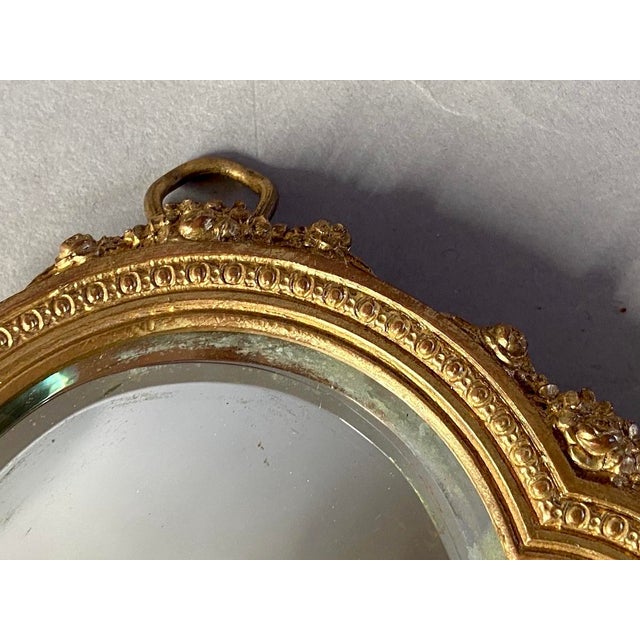 A charming 19th-century French hand vanity mirror in the elegant Louis XVI style, beautifully cast in bronze with floral...